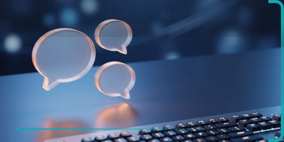 Drei leuchtende Chat-Sprechblasen ueber einer Tastatur als Symbol fuer einen KI-Chatbot auf einer Website