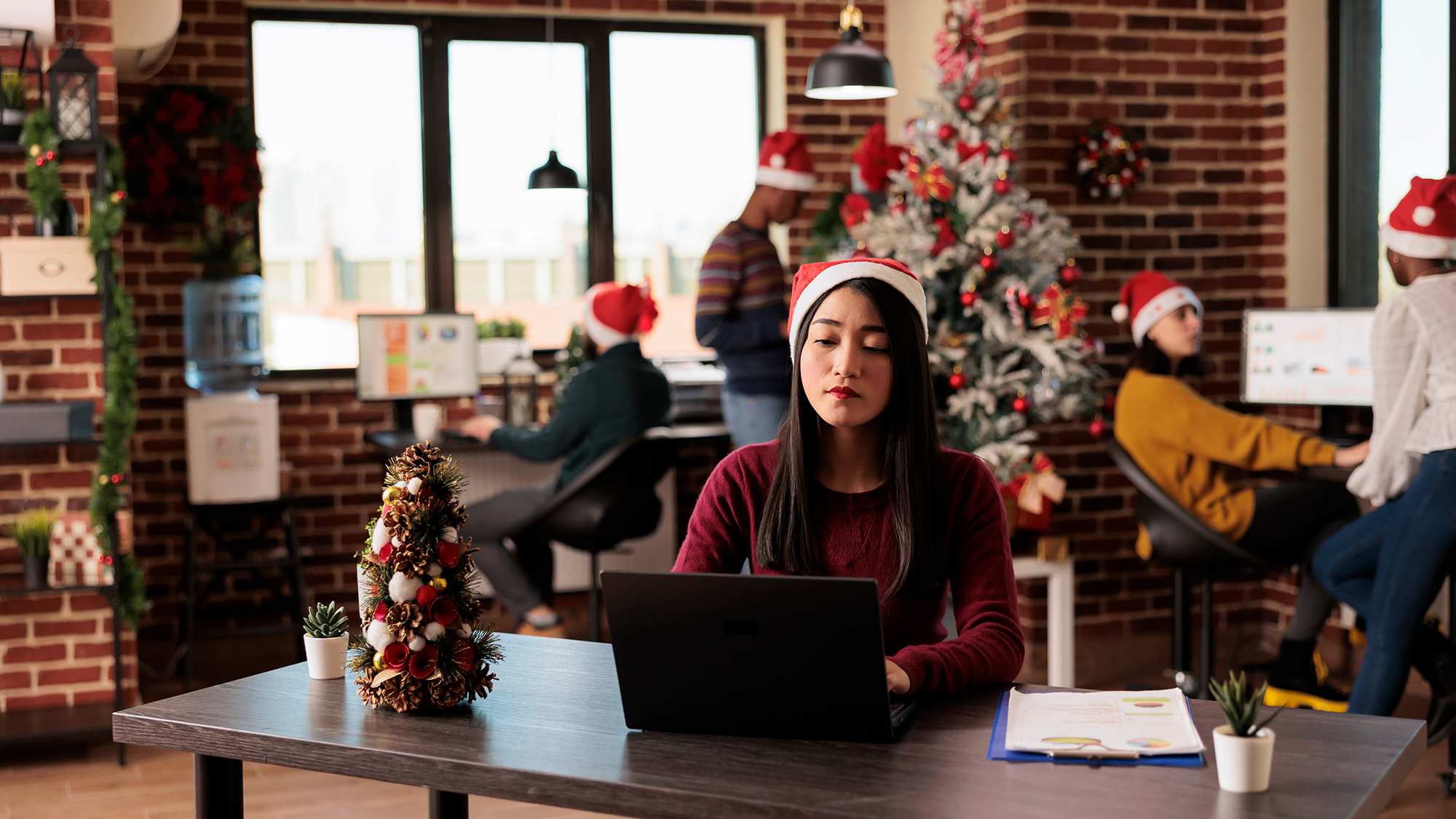 woman in santa hat working on laptop
