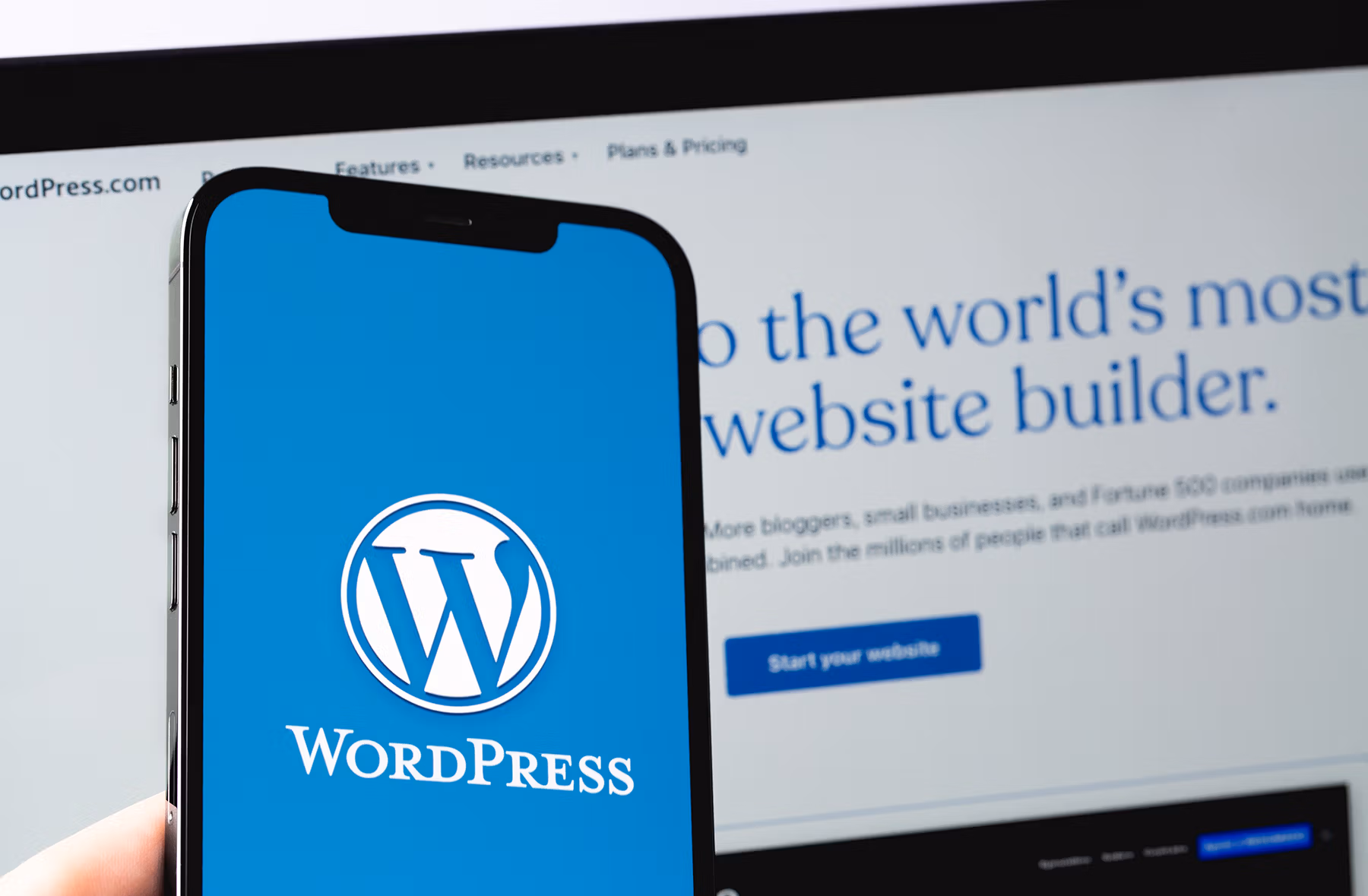 wordpress logo mobile app on screen smartphone iphone with macbo